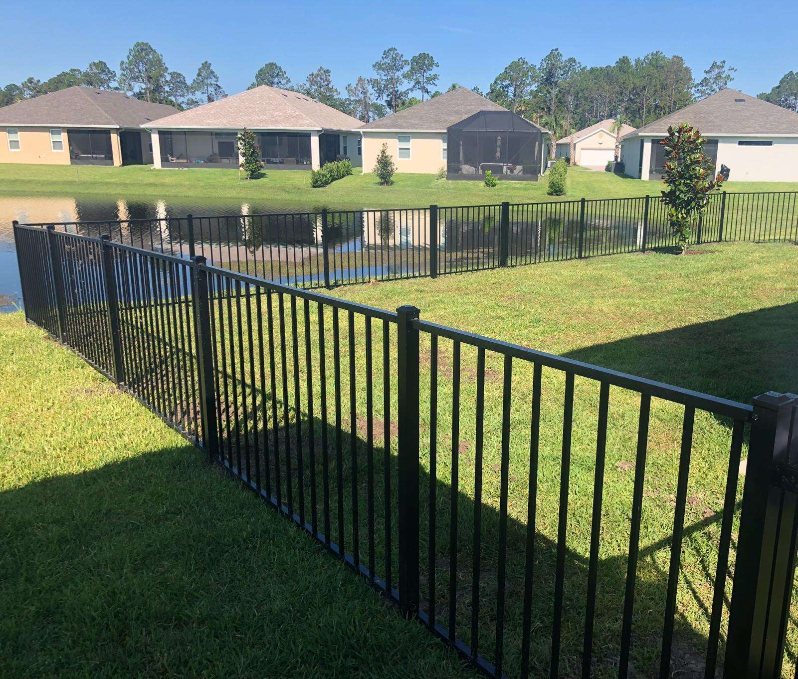 Black aluminum fence installed by Lex Fencing overlooking a neighborhood pond