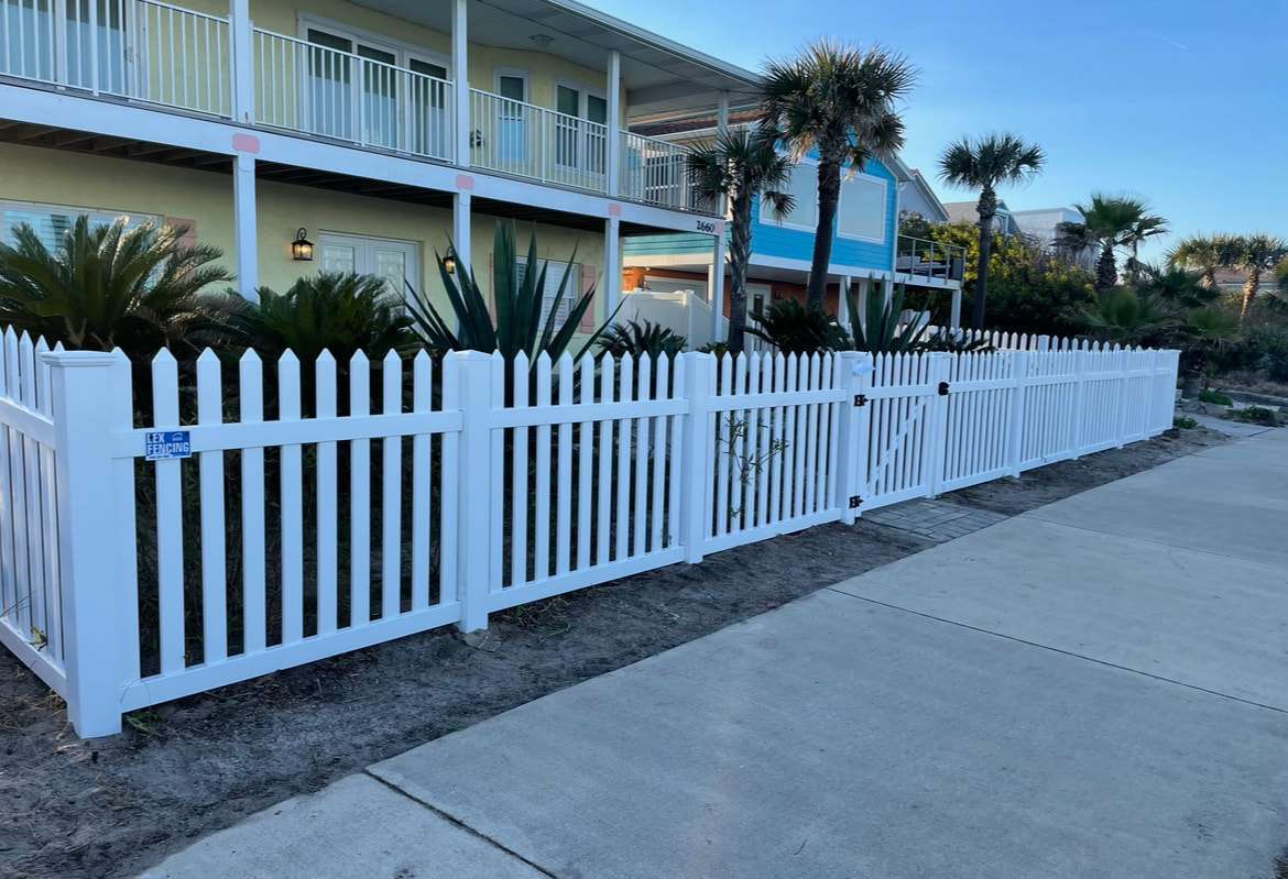 White picket fence installation with Lex Fencing job-site sign, coastal Palm Coast home